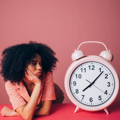 Woman looking at the pink alarm clock