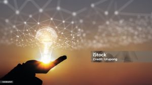 A decorative light bulb above a hand, with intricate designs on the light.