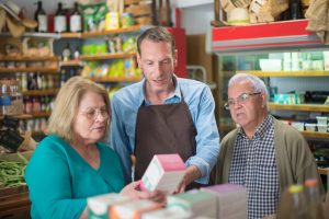 Store merchandiser and customers reading the product label together.