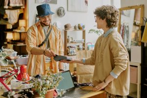 Smiling Man Paying for Purchase in Small Boutique
