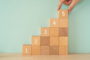 Step up; Wooden blocks with numbers and a hand.